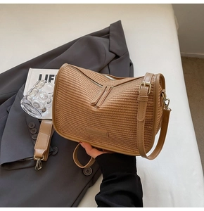 Detail of tan woven texture crossbody bag with zipper and adjustable shoulder strap