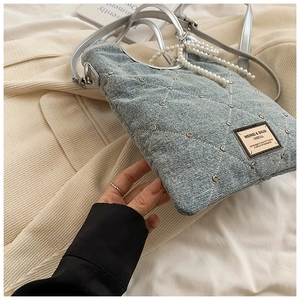 Détail du sac bandoulière en jean matelassé avec clous argentés et chaîne en perles