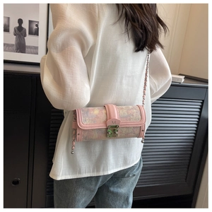 Detailed close-up of a pink cylindrical crossbody bag with art print and metal M logo