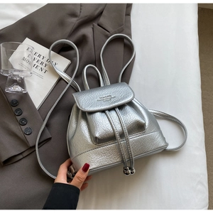 Detailed view of silver mini backpack with pebble leather texture and drawstring closure