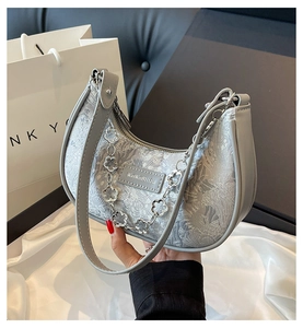 Détail du sac croissant à motif floral avec chaîne fleurie argentée et fermeture éclair
