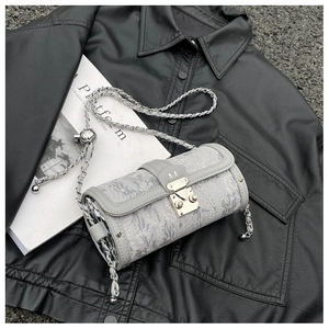 Detailed macro view of the grey jacquard cylinder bag with silver metal M-buckle clasp