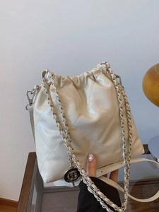 Elegant cream quilted bucket bag with silver chain strap and polished patent finish