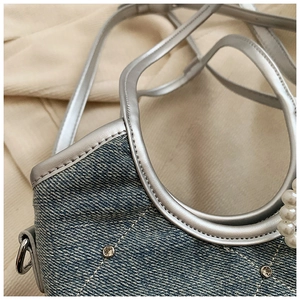 Détail d'un sac à main en jean matelassé bleu clair avec perles et strass brillants