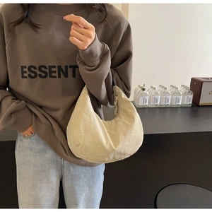 Close-up of the beige hobo bag showing its premium nylon texture and crescent shape