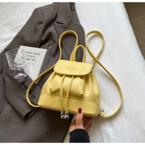 Detail of yellow mini leather backpack with drawstring closure and silver bead accents