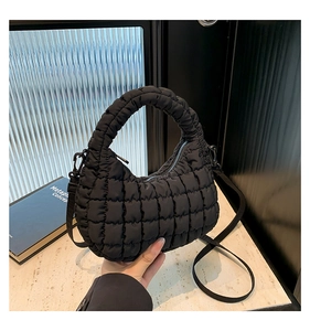 Close-up of black quilted bubble nylon handbag with stitched grid texture detail