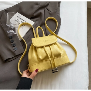 Detail of yellow lychee grain faux leather mini backpack with drawstring and metal beads
