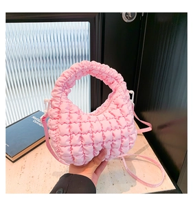 Detailed view of pink quilted bubble fabric and detachable shoulder strap on the dumpling bag