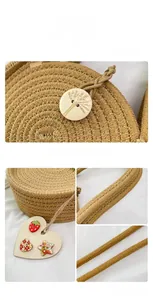 Detail of straw woven bag featuring a carved wooden button closure and colorful heart charms