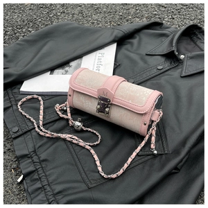 Detail of pink cylindrical chain bag with floral jacquard fabric and silver metal ball