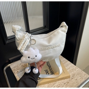 Détail du sac croissant blanc en nylon avec broderie et breloque nuage en peluche