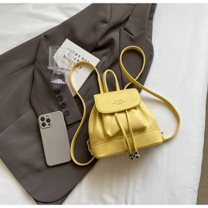 Detail of yellow pebbled leather mini backpack with drawstring and magnetic closure flap