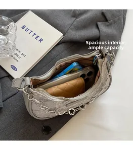 Vue détaillée d'un sac demi-lune gris montrant sa grande capacité pour téléphone et portefeuille