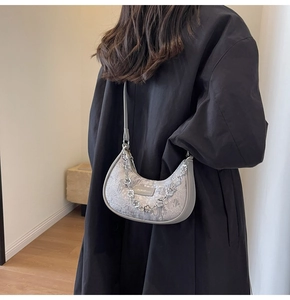 Détail du sac demi-lune gris en jacquard floral avec une chaîne argentée en fleurs de prunier
