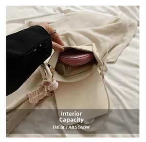 Detail view of the cream shoulder bag interior with spacious main pocket and zip pocket