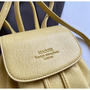 Detail of lychee pattern PU leather backpack featuring brand embossed logo and fine stitching