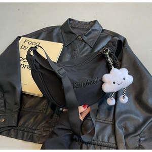 Détail du sac bandoulière en nylon noir avec broderie et breloque nuage en peluche