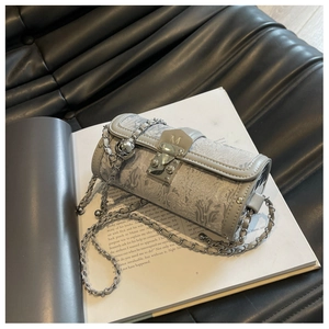 Close-up of grey cylinder bag with floral jacquard texture and silver M-buckle detail