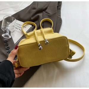 Detail of yellow drawstring bucket bag with silver metal beads and lychee grain leather