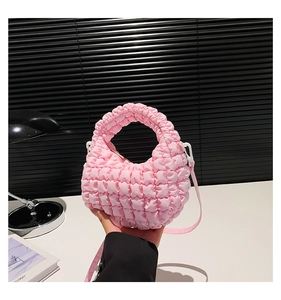 Detailed close-up of pink ruched fabric texture on a pleated crossbody crescent bag