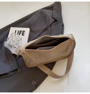 Detail of woven crossbody bag showing interior pockets and smooth zipper closure