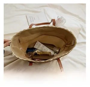 Detail view of woven straw tote interior with lace trim and secure zipper pocket