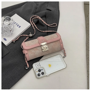 Detail of pink jacquard barrel bag showing metal M clasp and chain strap