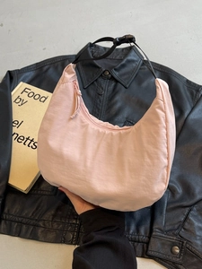 Pink nylon crescent shoulder bag with adjustable black strap and zipper closure
