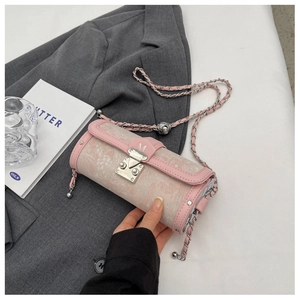 Detail of pink cylindrical crossbody bag with floral embossing and silver hardware