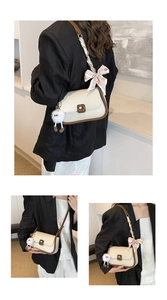 Detail of cream crossbody bag with brown trim, striped silk scarf, and plush charm