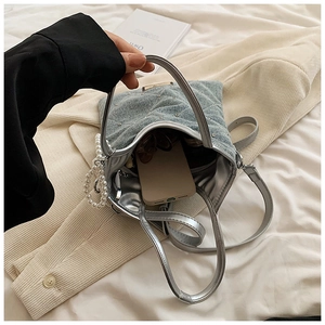 Détail du cabas en jean bleu clair avec surpiqûres en losange et breloque perle