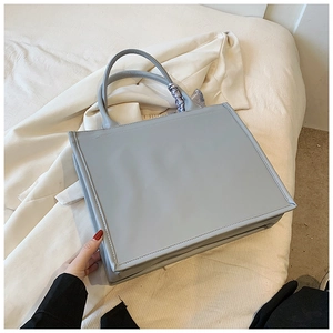 Détail du cabas en similicuir bleu clair avec anse en foulard de soie sur tissu doux