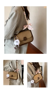 Detail view of khaki crossbody bag with silk bow and fluffy monster charm accessory