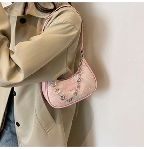 Détail du sac croissant rose avec motif floral textile et chaîne à fleurs argentée