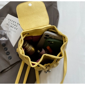 Internal view of yellow leather bucket backpack showing storage space and drawstring closure