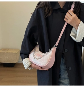 Détail d'un sac bandoulière jacquard rose avec chaîne métallique et bandoulière en cuir