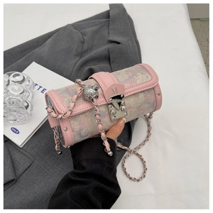 Close-up of jacquard cylinder bag featuring a pink leather trim and M-logo metal clasp