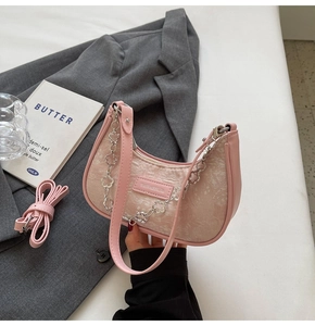 Détail du sac hobo en jacquard rose avec chaîne florale et bandoulière en cuir