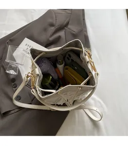 Spacious interior of white tweed bucket bag with drawstring and daily essentials
