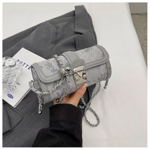 Detail of grey jacquard barrel bag with floral texture and silver chain strap