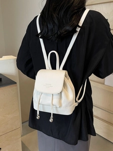 Minimalist white leather backpack with silver drawstring details on a female model
