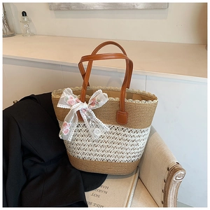 Detail of woven straw tote bag with white lace trim and floral pink bow on a chair