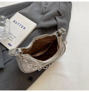 Vue détaillée de l'intérieur d'un sac hobo gris avec doublure rayée et chaîne fleur