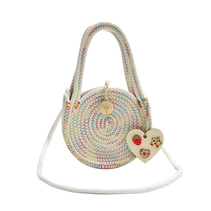 Handmade round straw woven bag with colorful spiral stitching and wooden heart charm