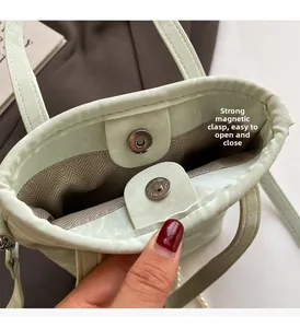 Detail showing the magnetic closure and herringbone fabric lining of the mint green bag