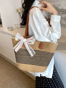 Large woven straw tote bag with black stripes and floral lace bow for summer beach travel