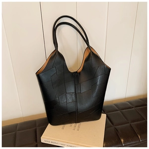 Détail du grand sac cabas en cuir noir avec patchwork géométrique et longues anses d'épaule