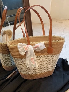 Large woven tote bag with brown leather handles and white lace floral bow decoration