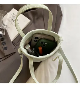 Top-down view of a light green bucket bag showing spacious interior with personal essentials
